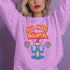 A Christmas sweatshirt featuring a playful design with a cartoon Baphomet goat character wearing a Santa hat. The design includes the text "All Hail Santa" above the goat, with pentagrams in flames on either side. The goat is depicted in a meditative pose, adding a humorous and irreverent twist to holiday attire.